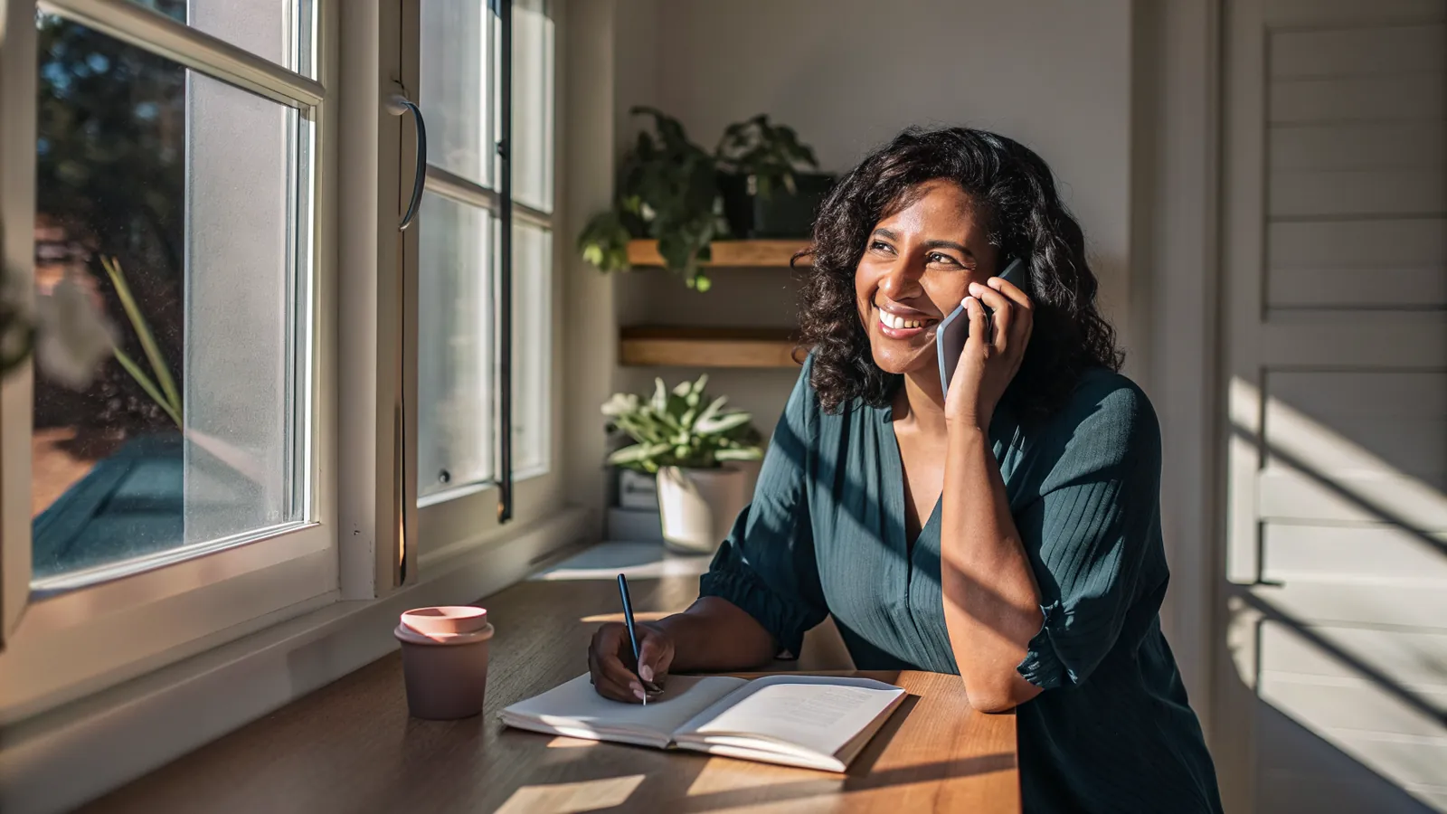Homeowner smiling on a phone call at a home desk