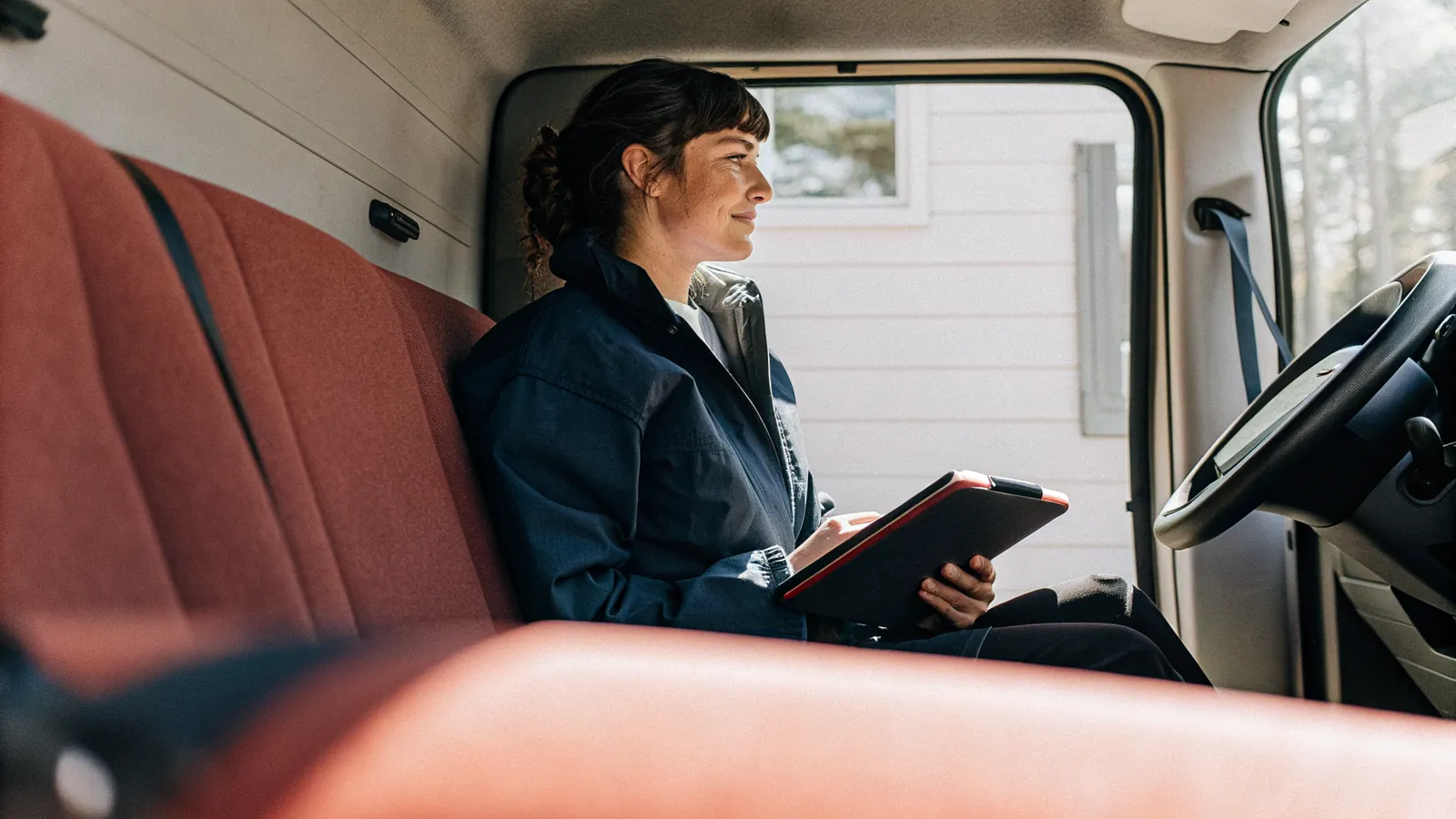 Pro reviewing job details on a tablet in a work truck